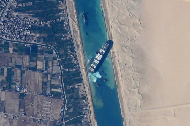 Bird's eye view of a large container ship stuck in a river.