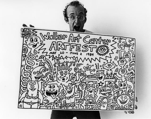 A man yells with joy at the veiwer while holding a poster filled with cartoon like illustrations and the title "Walker Art Center Art Fest."