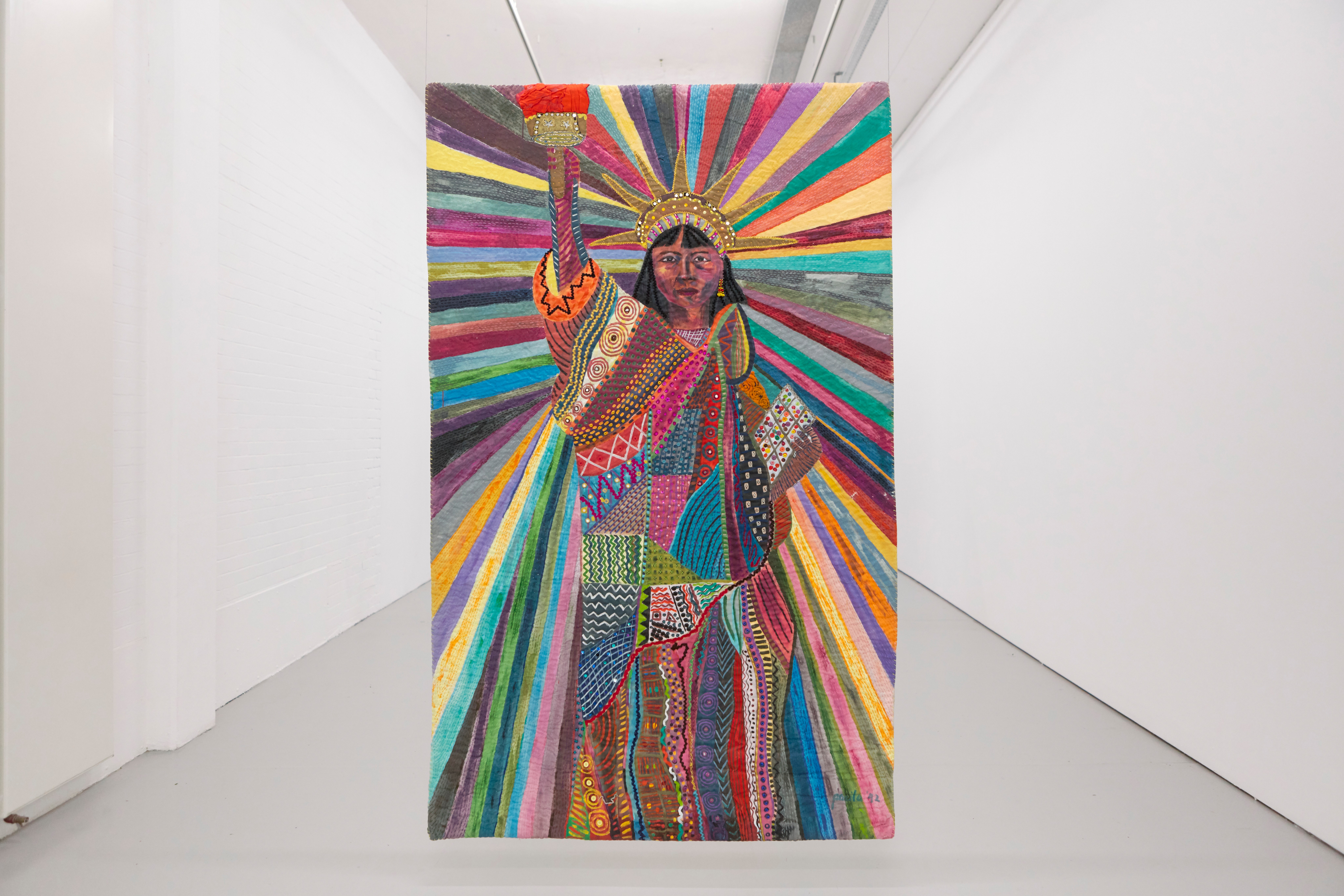A large colorful artwork of the Statue of Liberty hangs in a white art gallery.