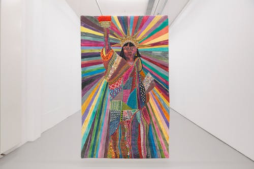 A large colorful artwork of the Statue of Liberty hangs in a white art gallery.