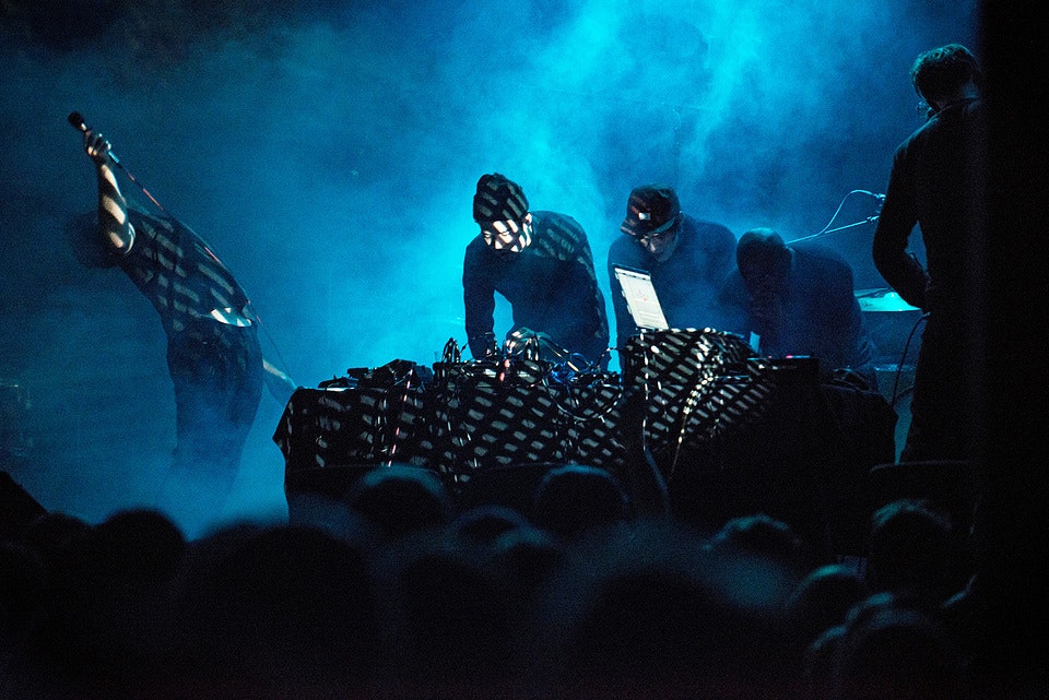 Blue/black image of a concert scene.