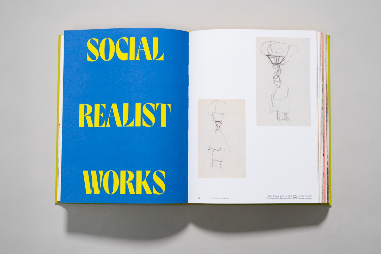 Spread of a large art book is open to a page of an essay with the title Social Realist Works.