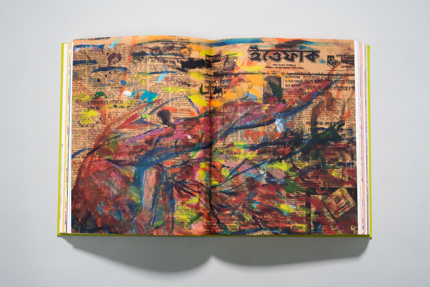 Spread of a large art book is open to a page of a colorful painting.