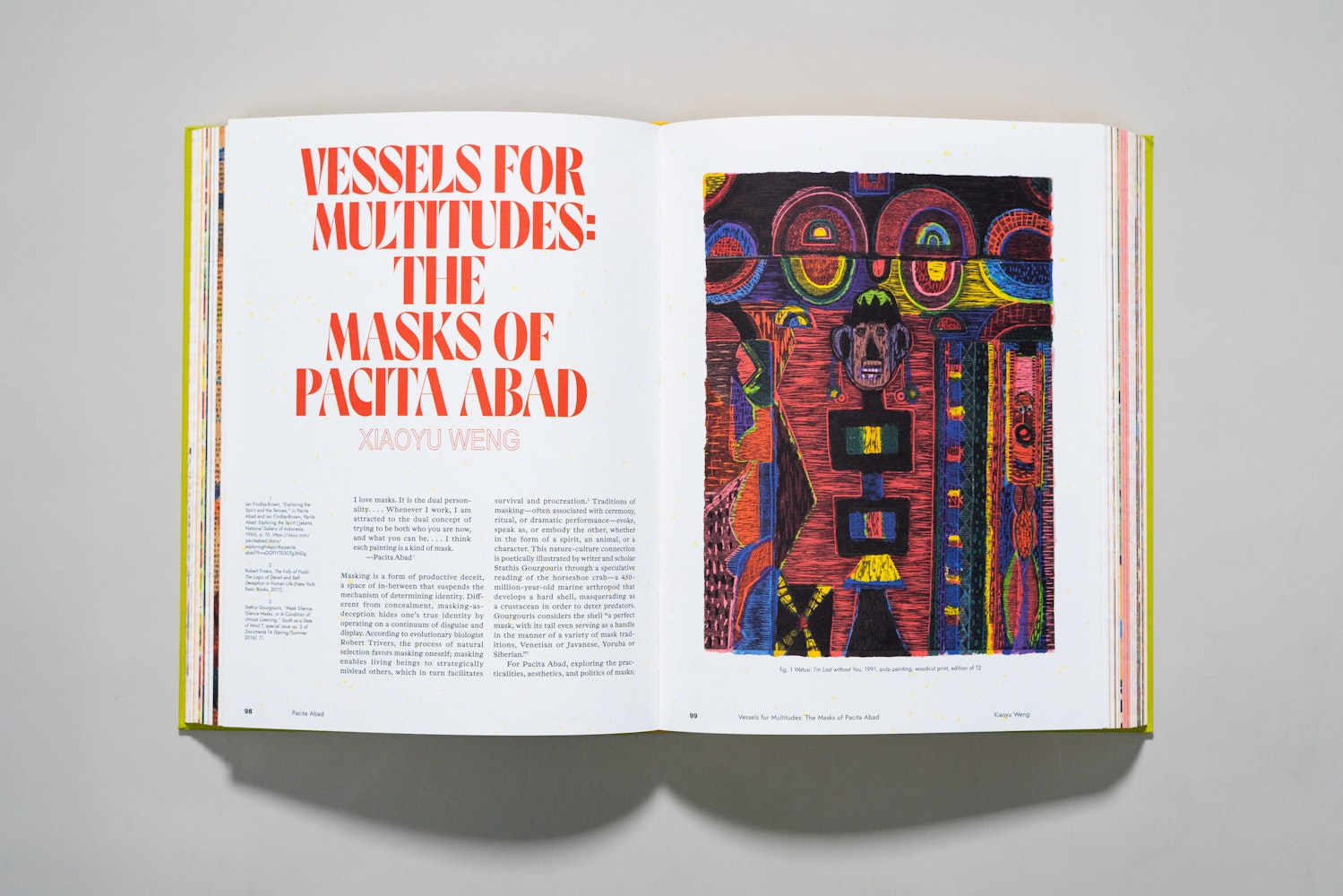 Spread of a large art book is open to a page of an essay with the title Vessels for Multitudes: The Masks of Pacita Abad.