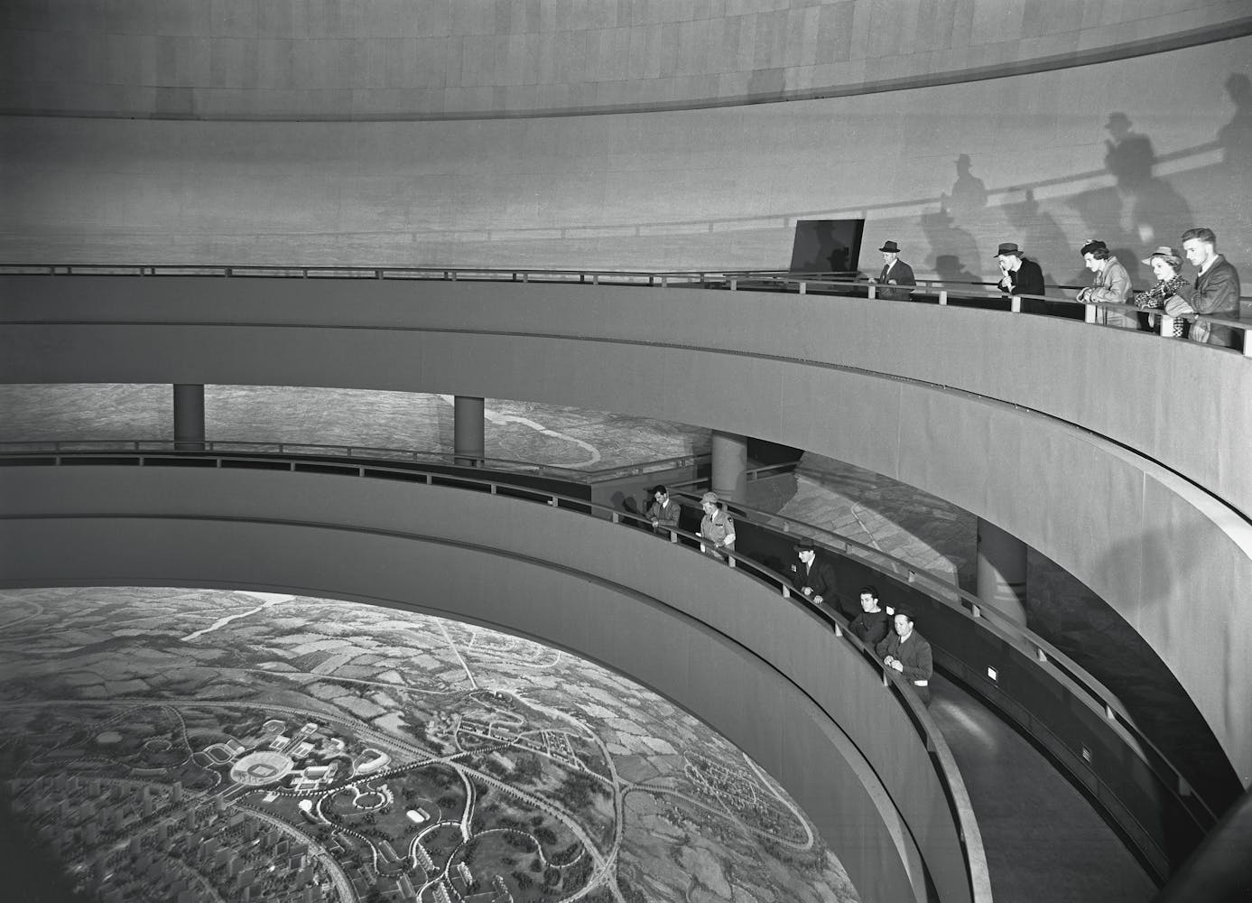 Image of people looking down at a large display of aerial photography