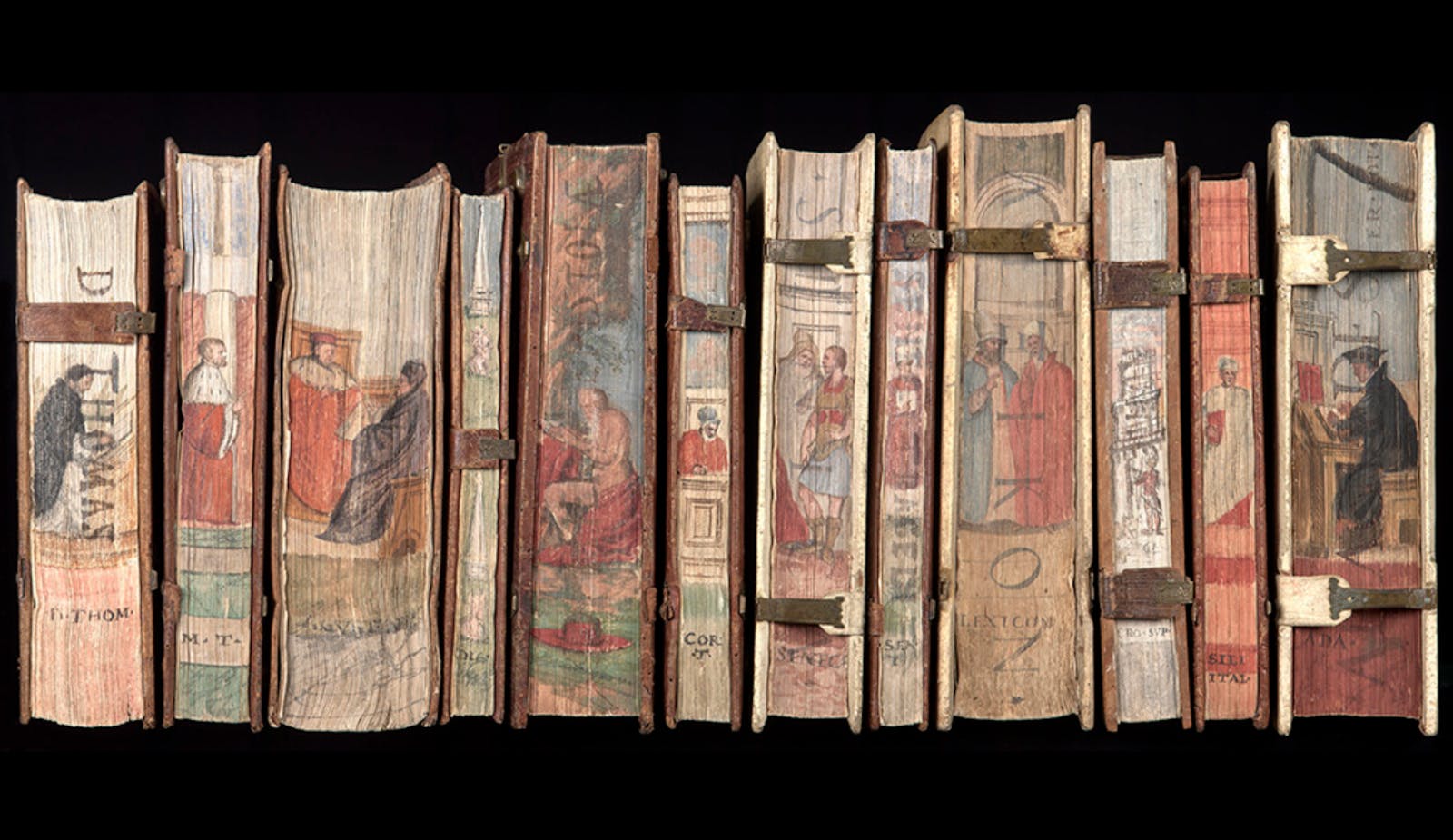 Many old books with image spainted on the spines are lined up next to one another.