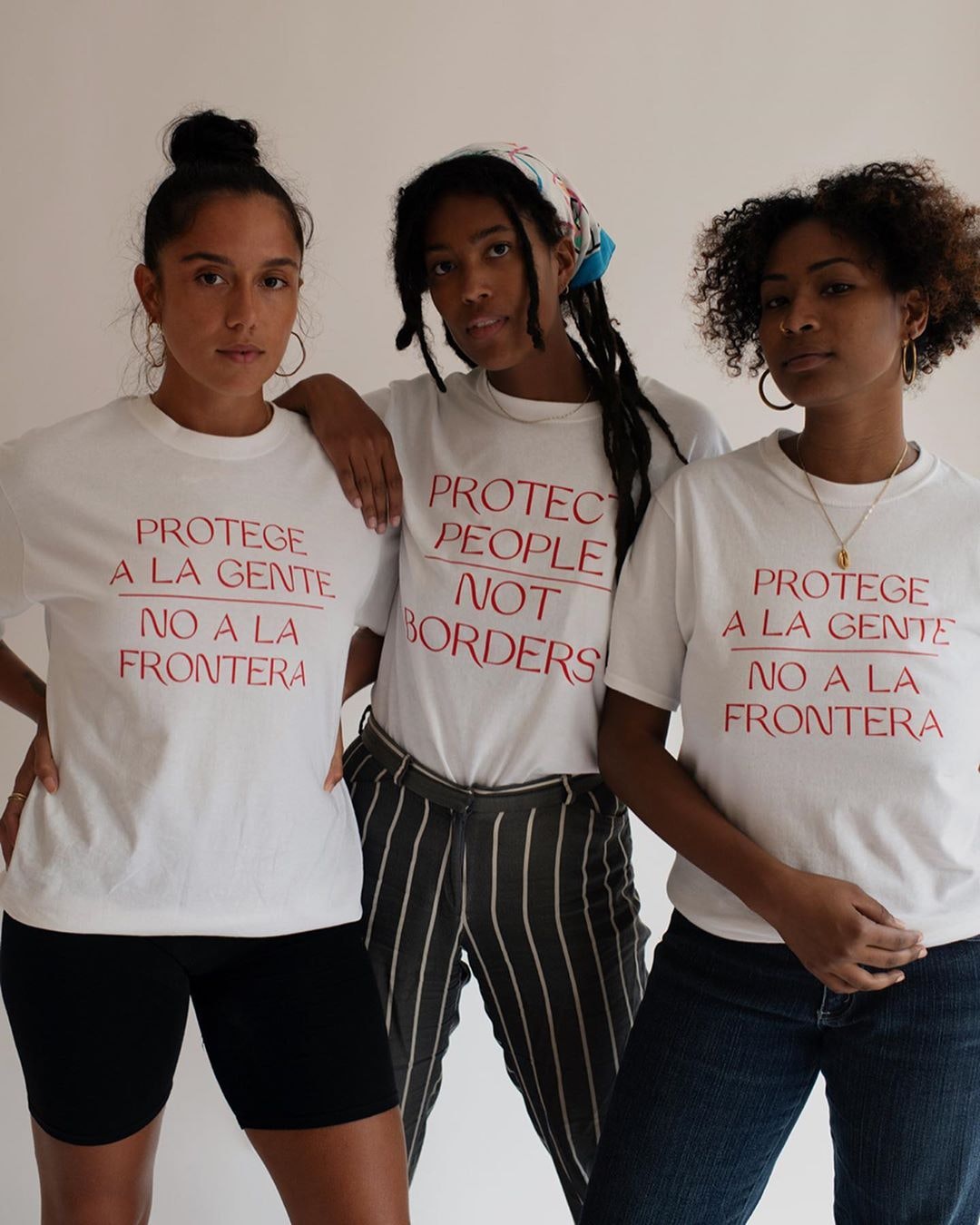 three people starting in tee shirts that say Protege a la gente/No a la frontera
