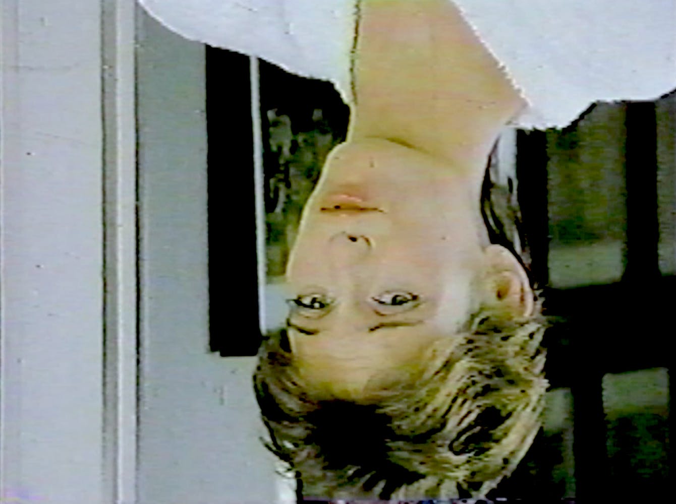 an upside down image of a woman in a white shirt.