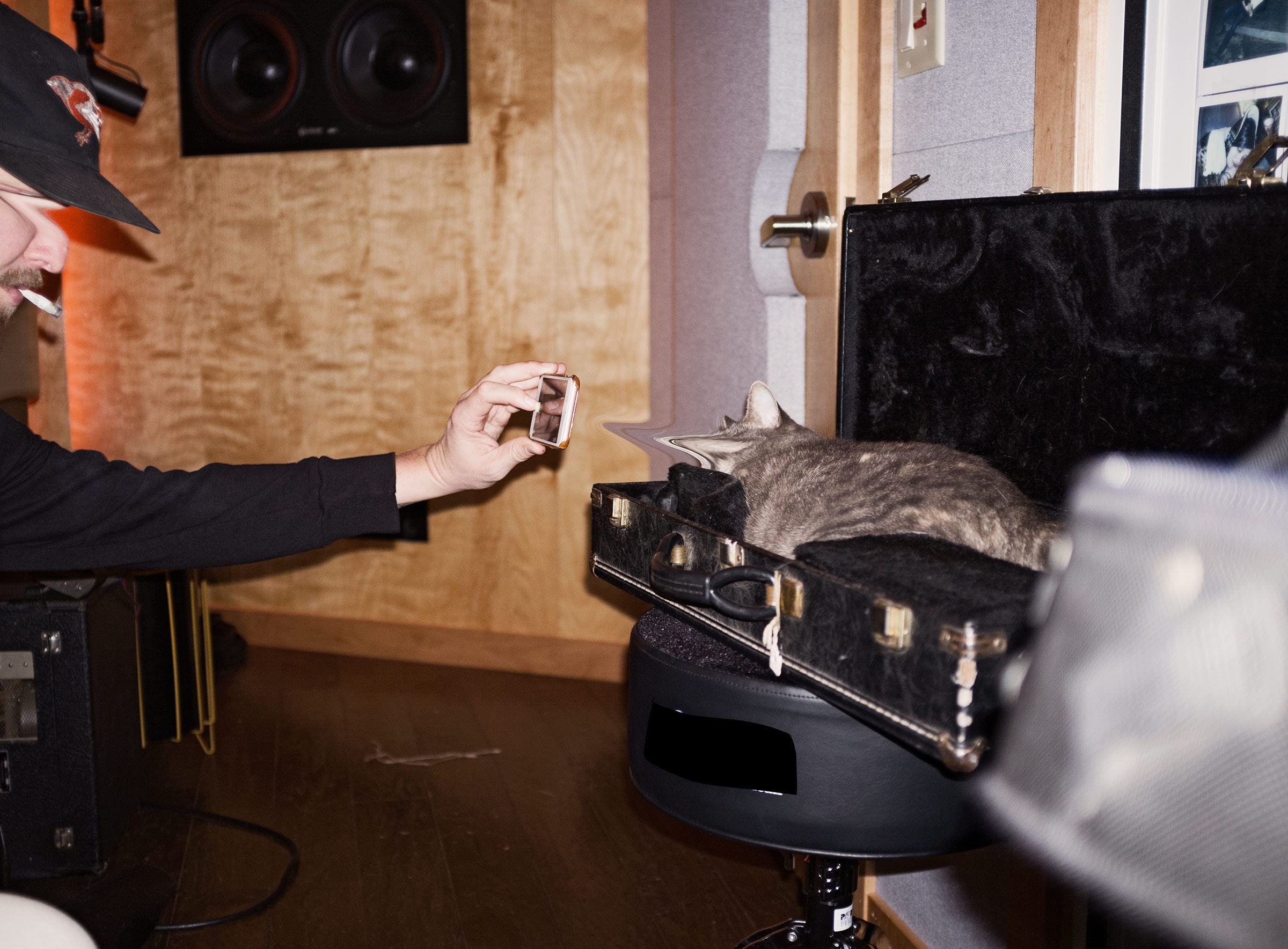 man taking photo of a cat on piano