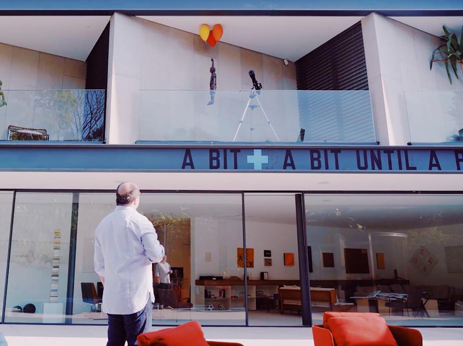 Man standing in front of modern home with art displayed