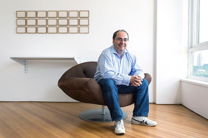 Man sitting in chair in front of art on wall