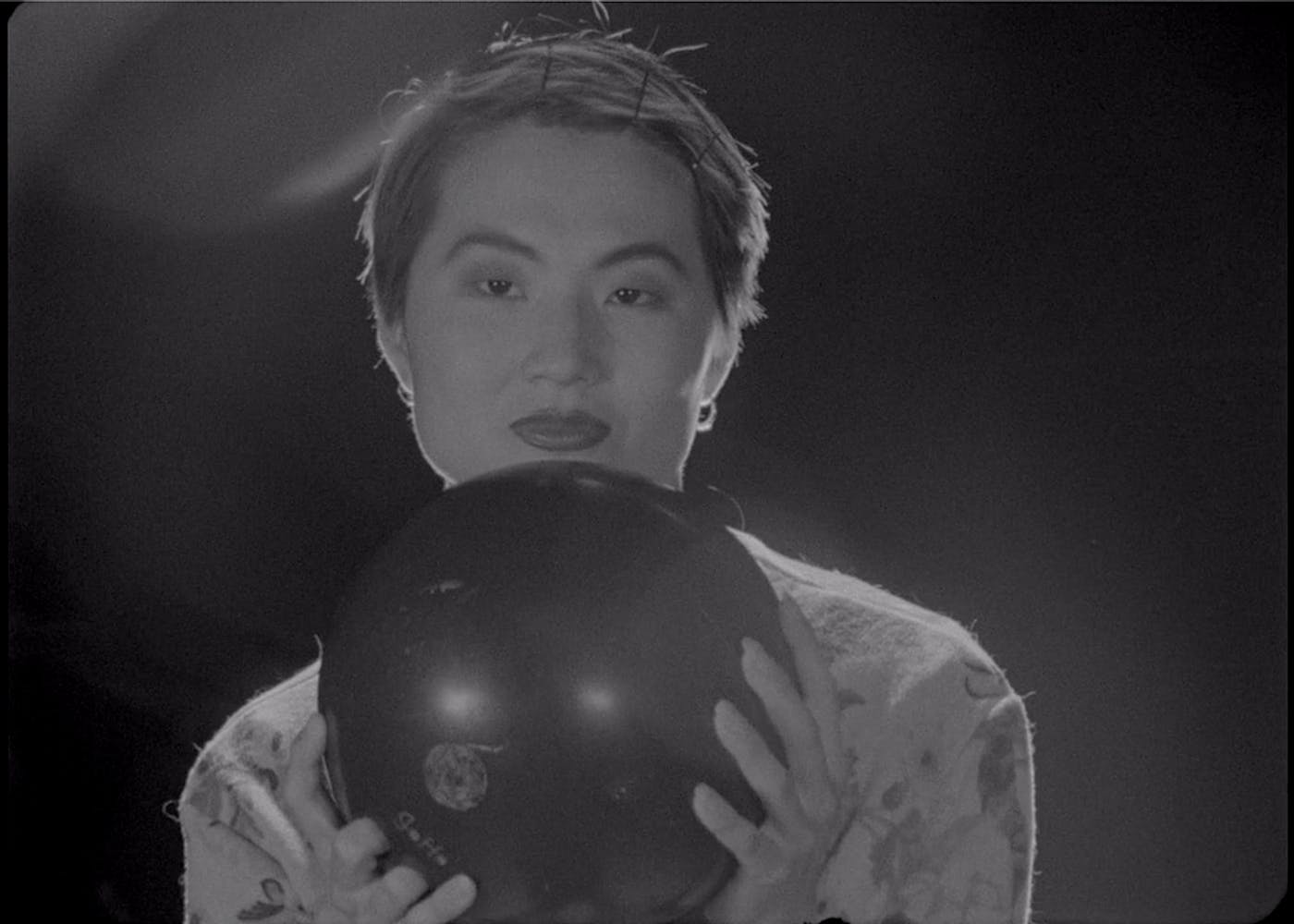 Woman holding bowling ball with both hands