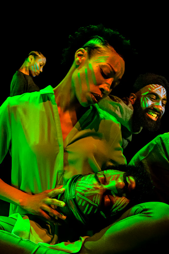 image of dancers superimposed on each other, bathed in colorful light with black background