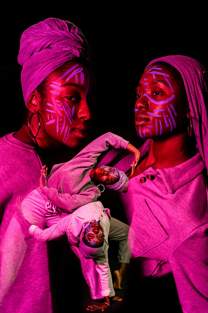 image of dancers superimposed on each other, bathed in colorful light with black background