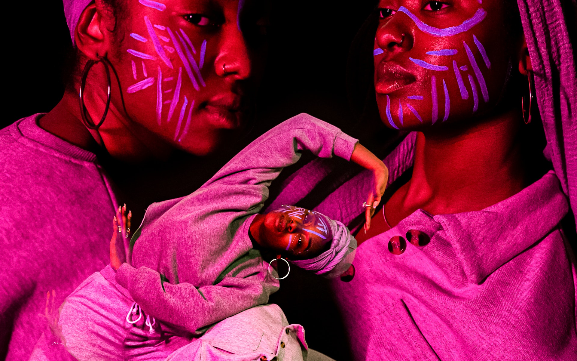 image of dancers superimposed on each other, bathed in colorful light with black background