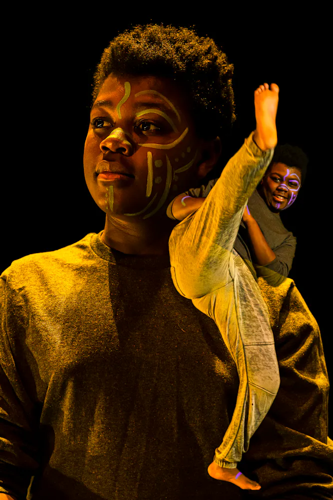 image of dancers superimposed on each other, bathed in colorful light with black background