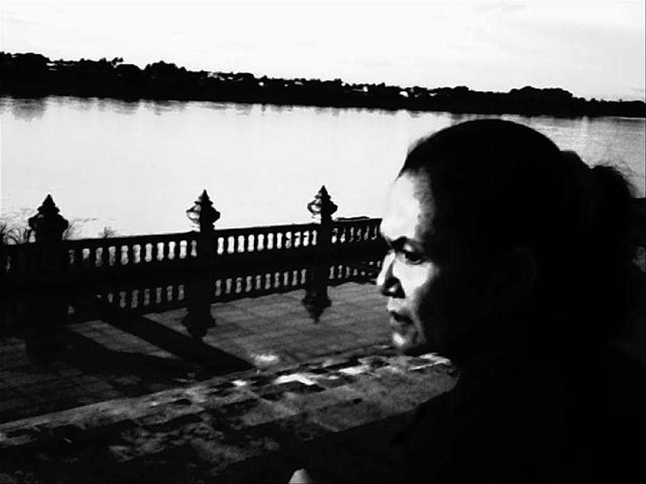 b/w photo of man looking out over river