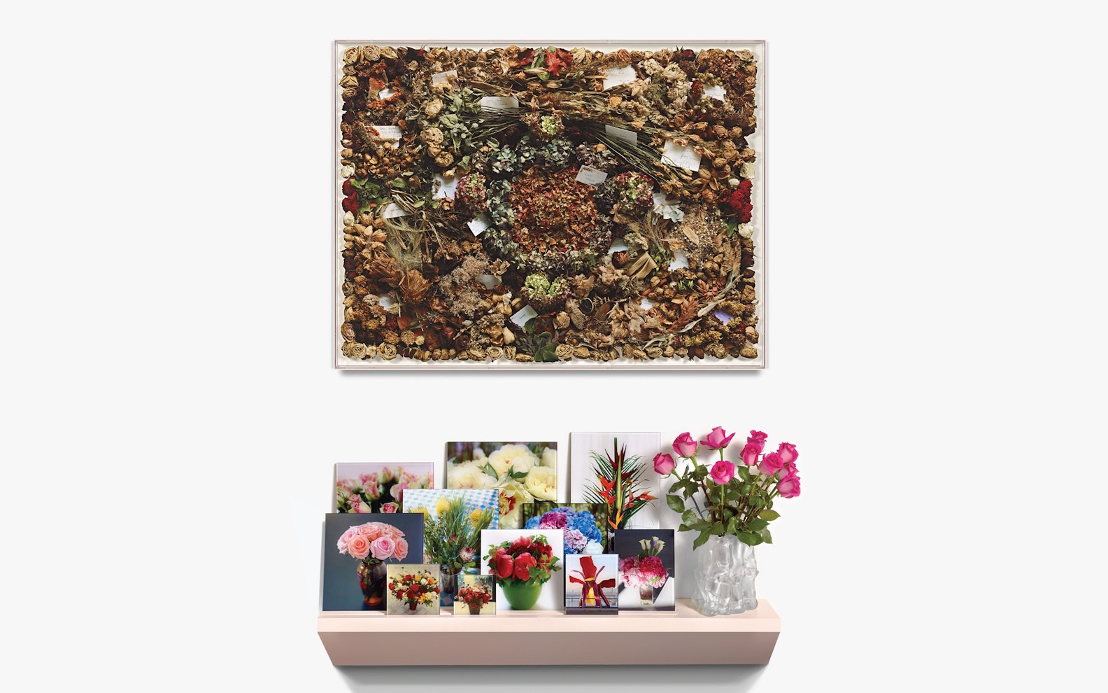 Calle-Lunch-Hero Art with flowers on a wall, and a shelf below with photos of fresh flowers and a vase of pink roses