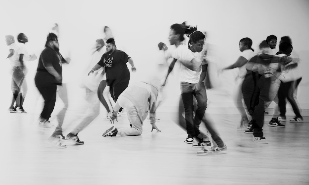 Black and white image of dancers in motion superimposed on each other