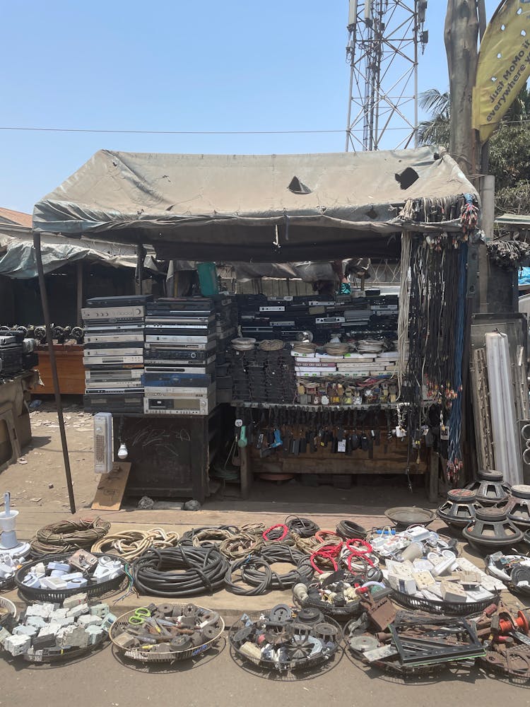 Piles of electronics and cords are gathered under a tent.