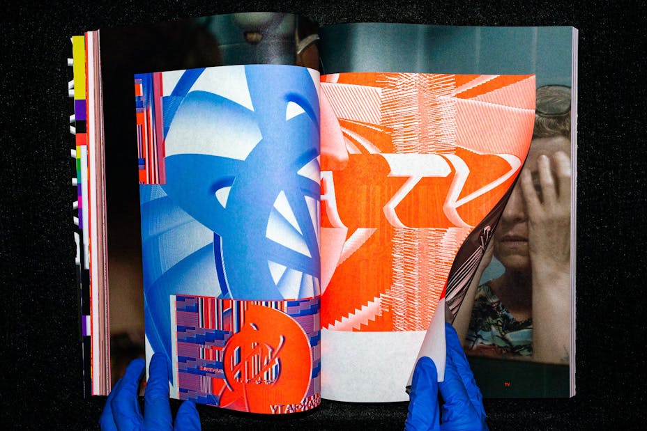 Hands wearing plastic gloves flip through a book.