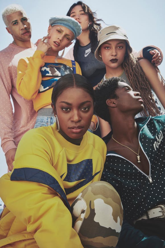 A group of young adults pose outside while wearing Nike sportswear