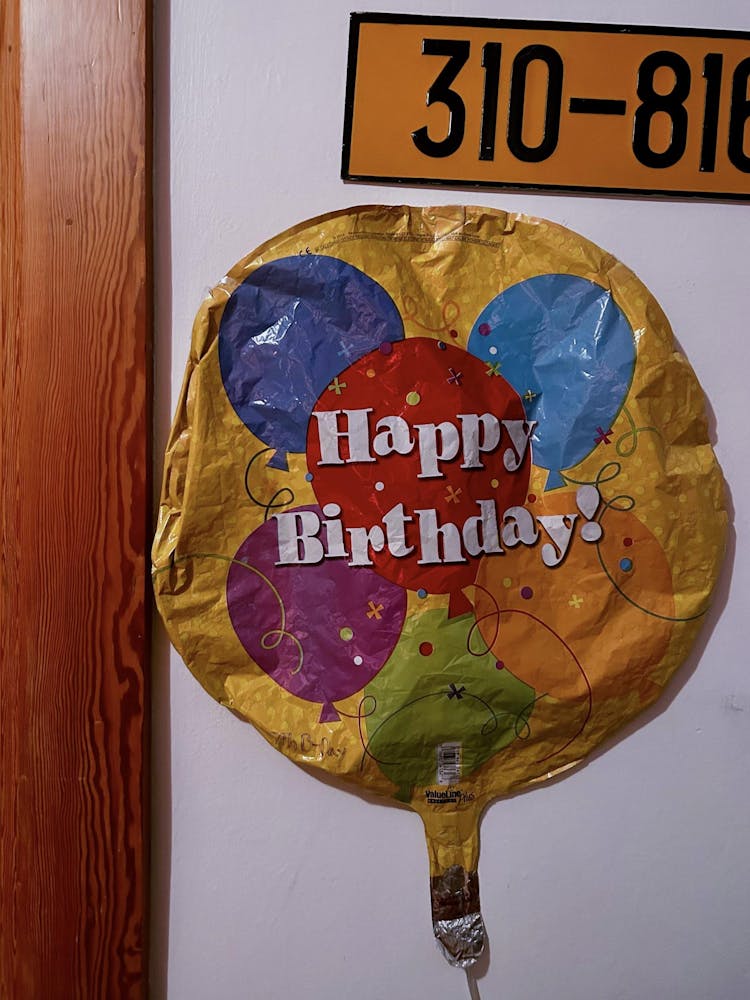 a birthday balloon and numbered sign displayed on a wall