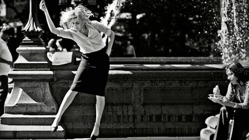 Black and white film still of Greta Gerwig playing Frances Ha dancing in front of a fountain in a park