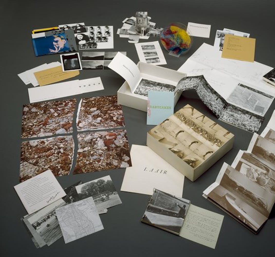 A group of artist's books and spread out over a table.