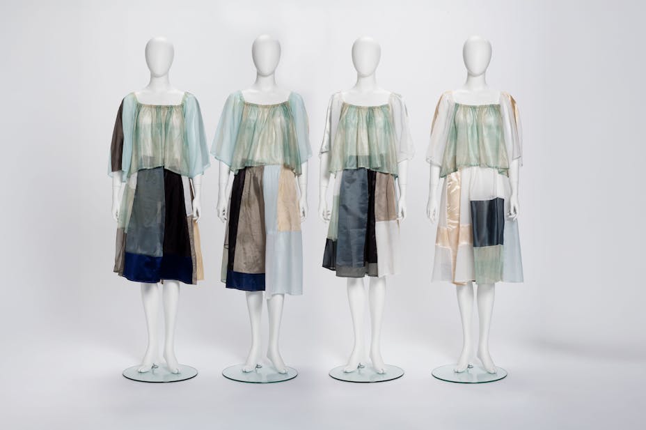 four mannequins in translucent skirt and top sets. the sets are made with a patchwork of cool-toned panels in shades of grey, blue, and green.