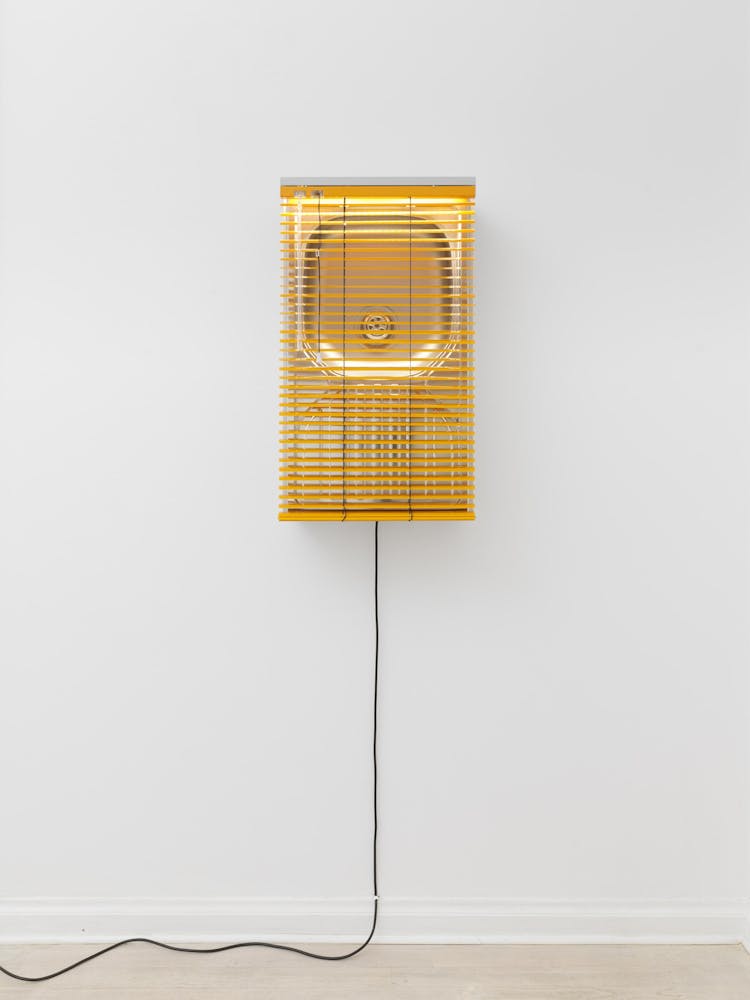sculpture of a golden sink, situated upright on the wall and enveloped with glowing yellow light