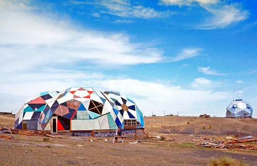 Colorful geodesic domes in a barren landscape with blue sky