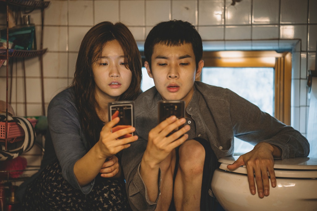 Two young adults in South Korea peering at phones