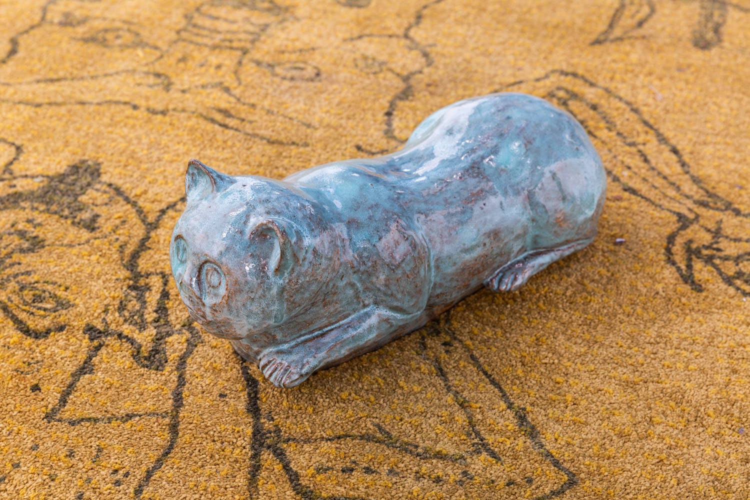 Light blue cat figurine on orange surface