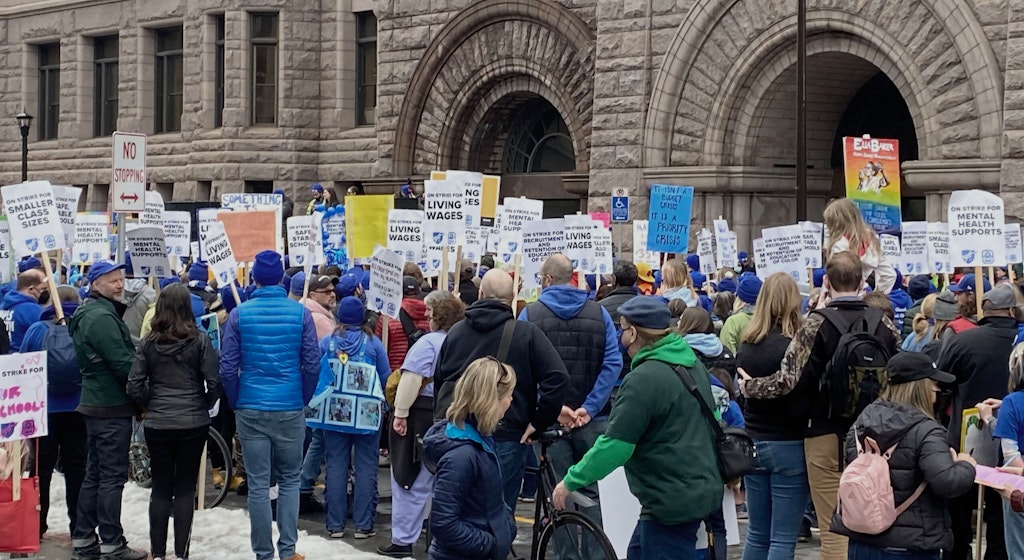 A group of adults picket outside of the Minneapolsi City Hall.