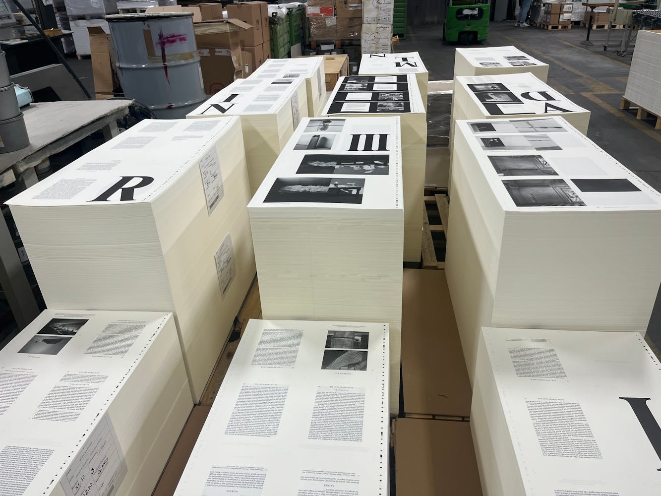 Large ammount of printed sheets are stacked in groups in a factory.