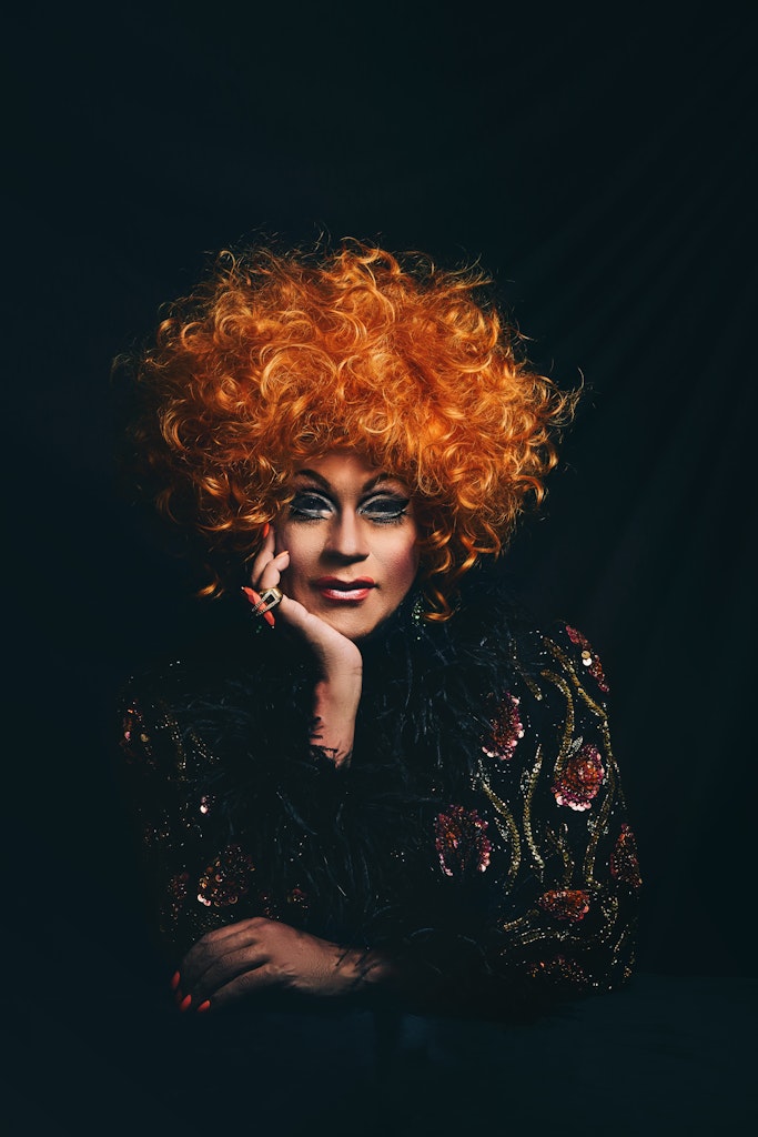 A group of adults, mostly in white shirts, dance in retro dance space.