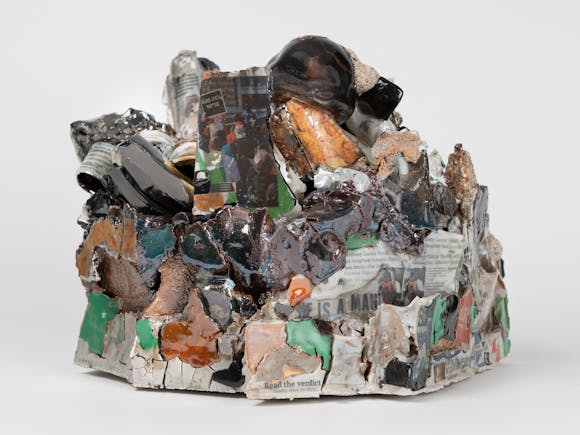 Sculptural work consisting of colorful stoneware, porcelain, and newspaper decals