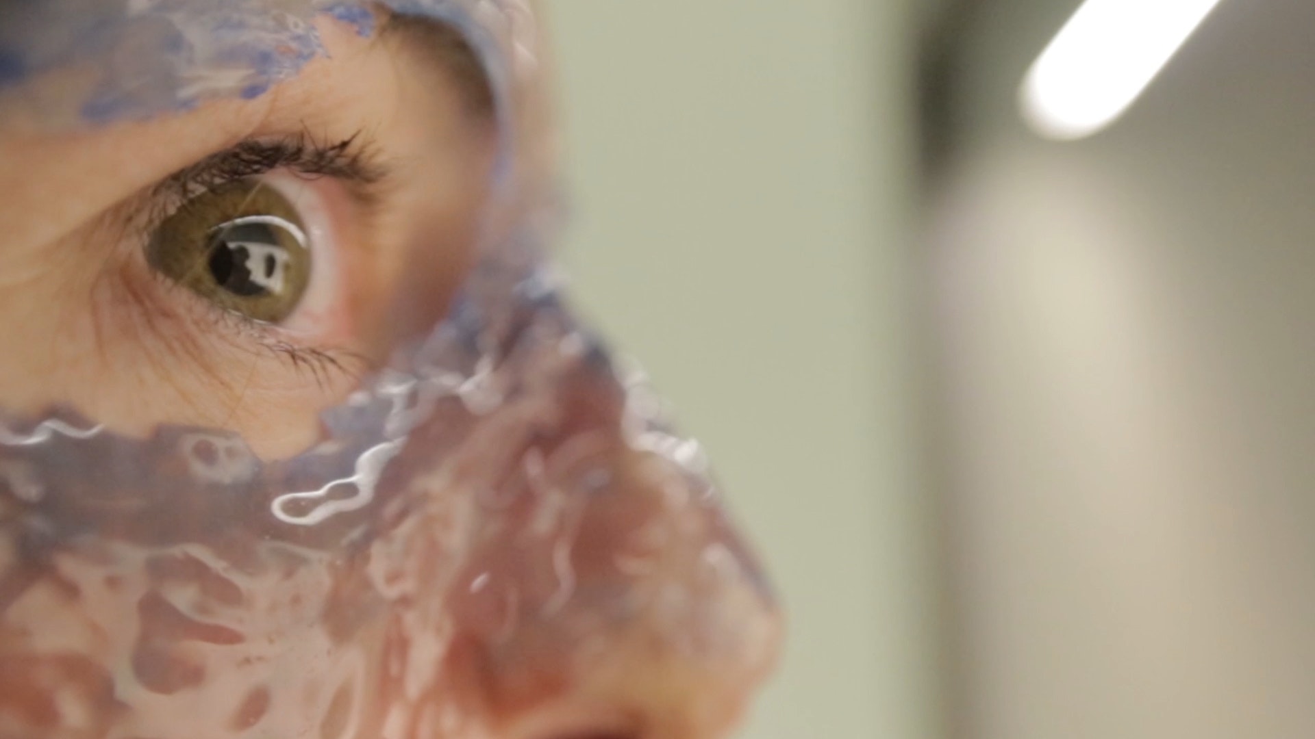 Close up of human eye with gelatin coating cheek and nose