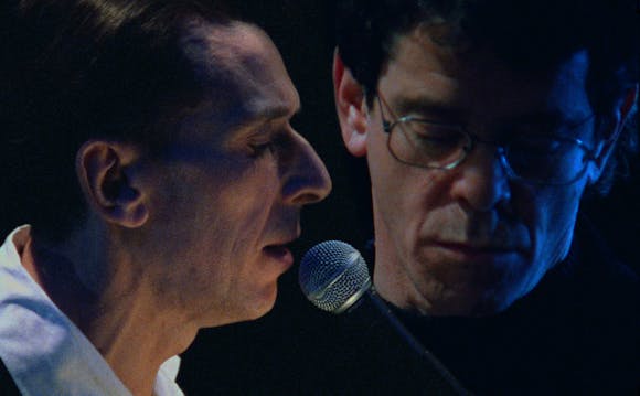close up image of Lou Reed and John Cale performing.