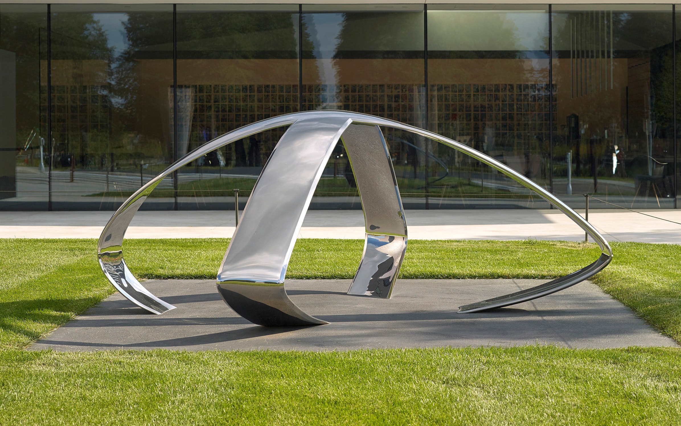 Image of shiny metal sculpture surrounded by grass