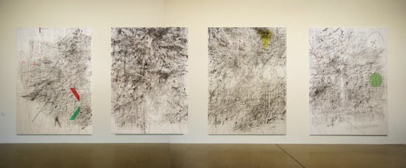 Four large abstract paintings with detailed line work hanging on a gallery wall