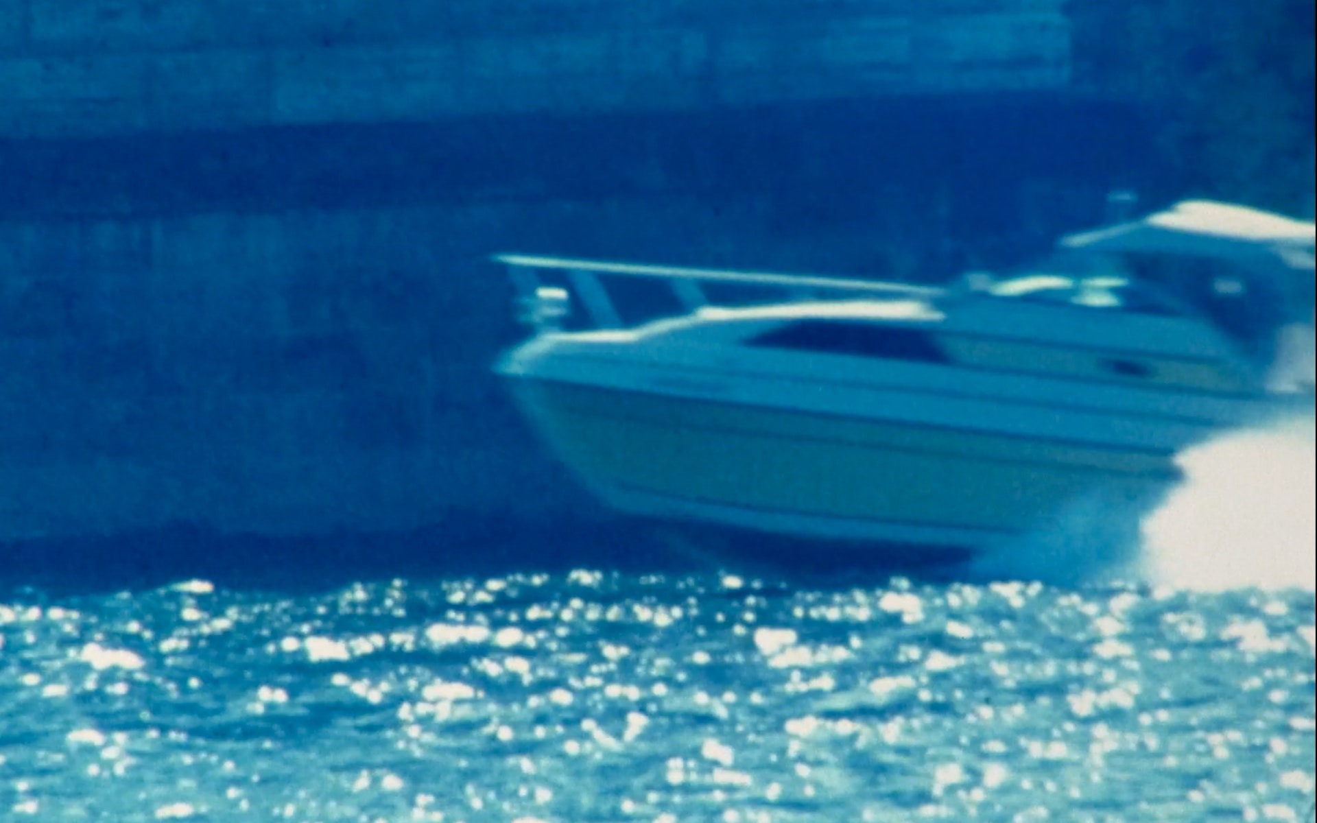 A yacht speeds across water.