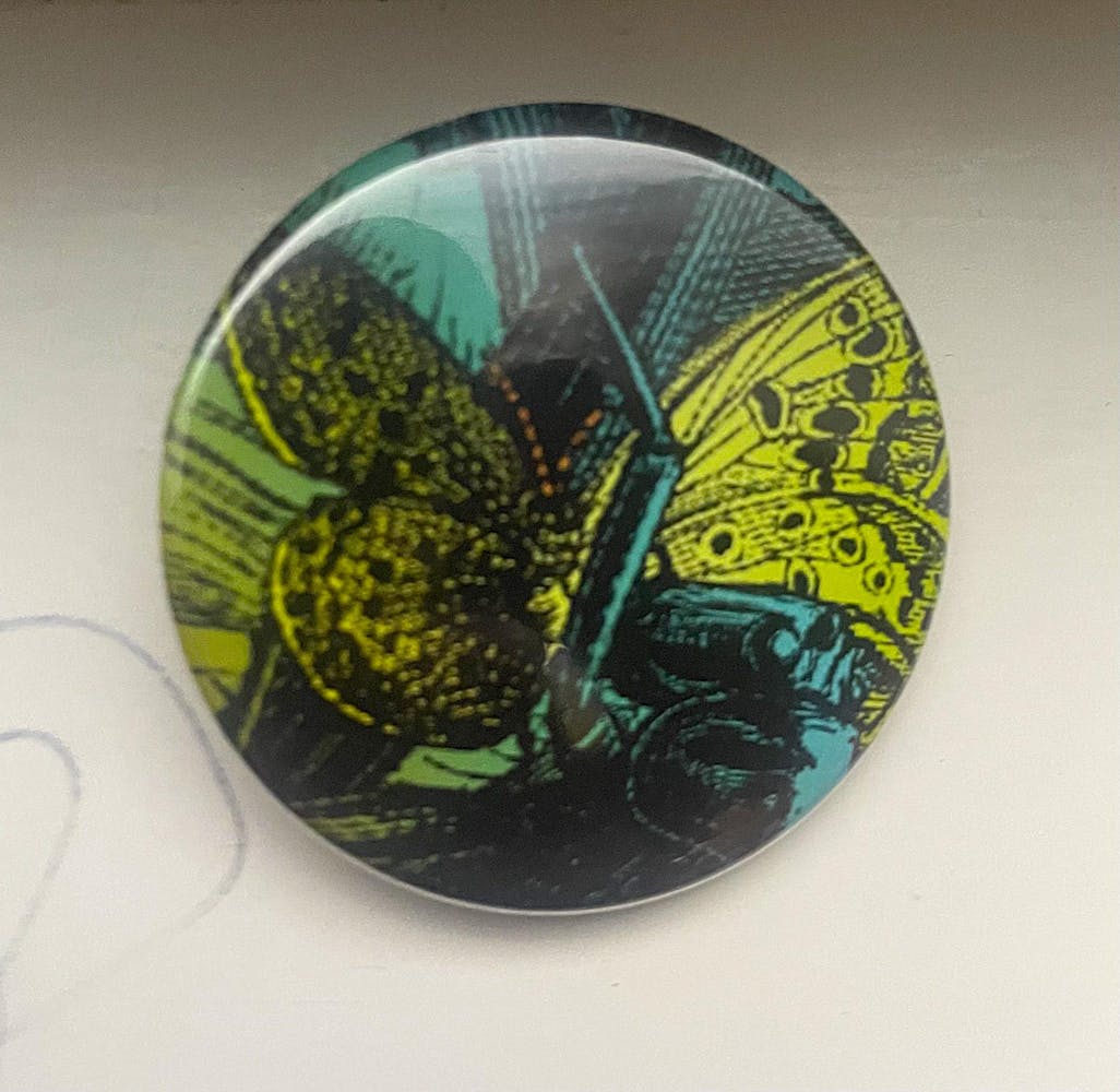 a pin with an image of a blue and yellow butterfly