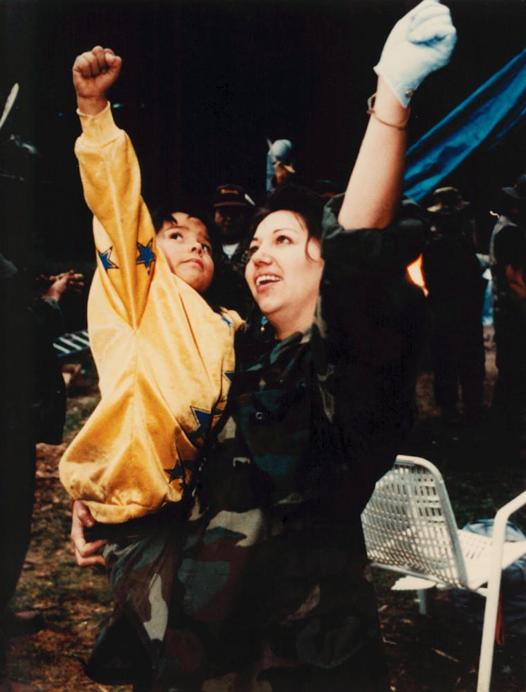 A woman and child raise their fists in victory before coming out from behind the barricades at the end of the Oka crisis over Mohawk land rights.