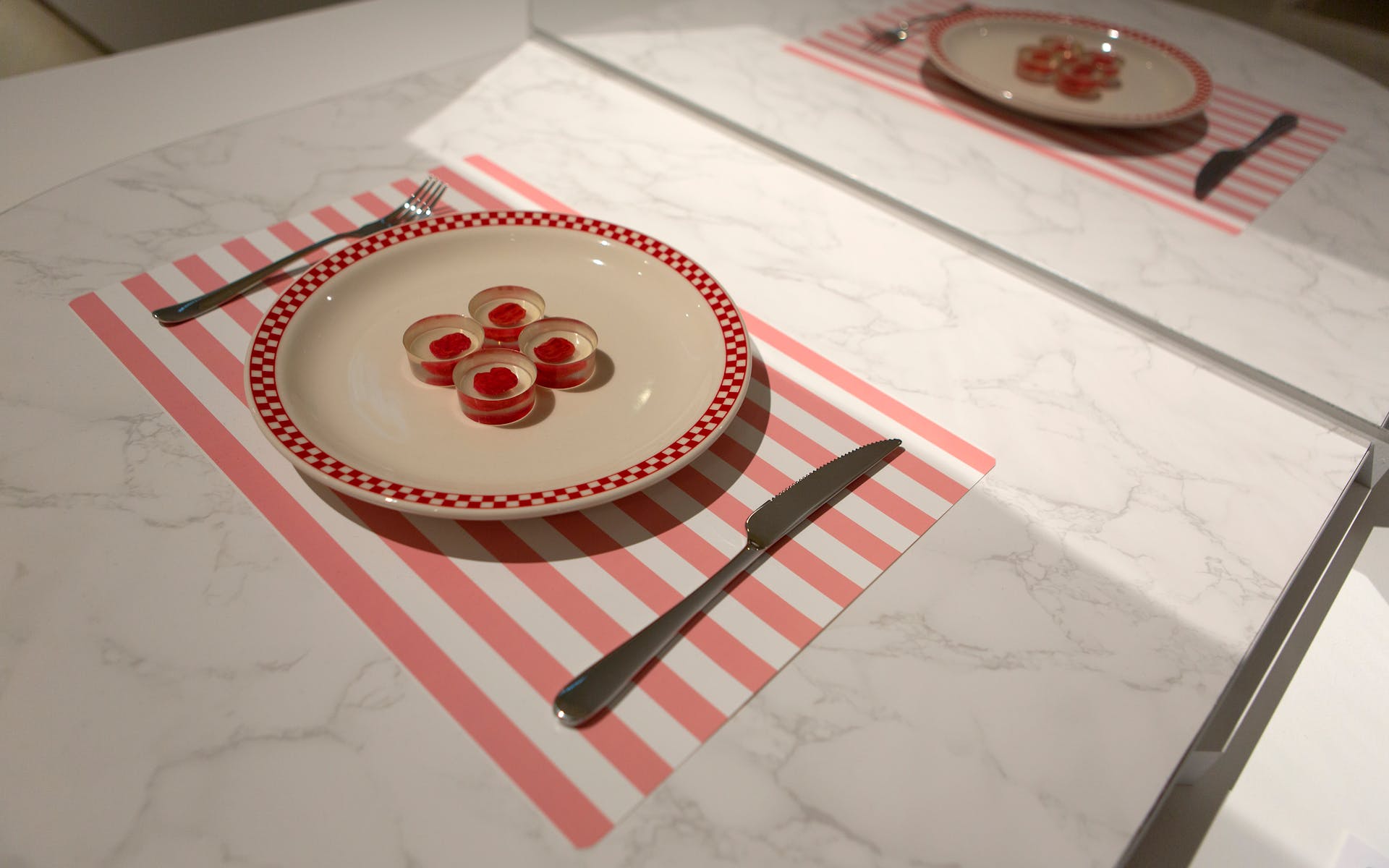 A placemat, knife and fork, and plate with four translucent disks
