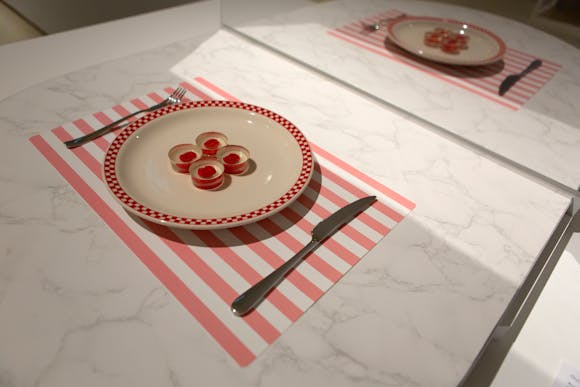 A placemat, knife and fork, and plate with four translucent disks