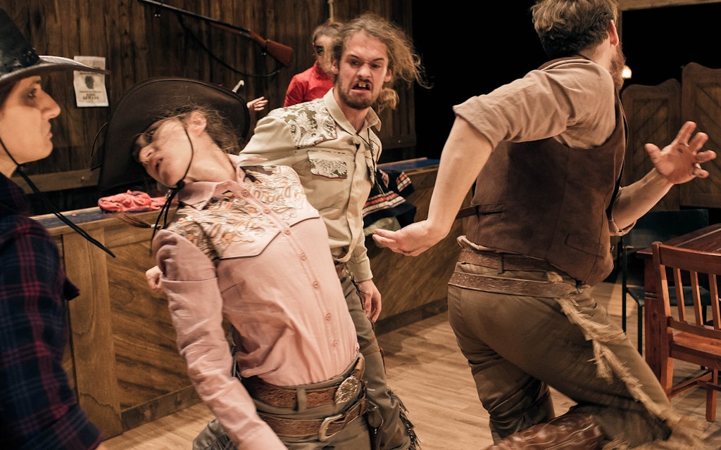 People in Western style clothing reenacting a bar fight.