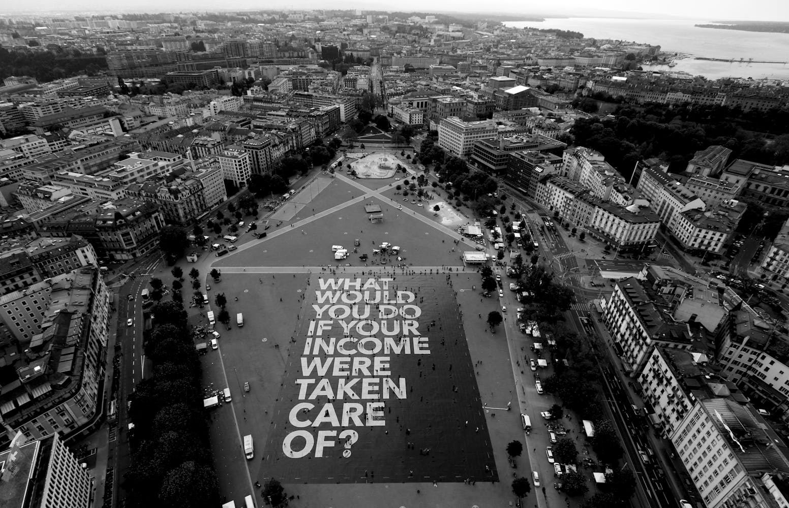 Image of city square with giant poster on ground that reads 