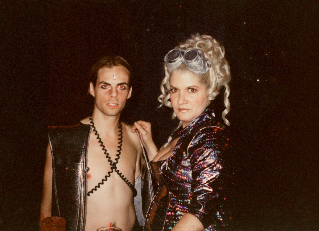 Two adults embrace in a club scene